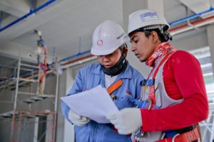 two construction workers reading a paper