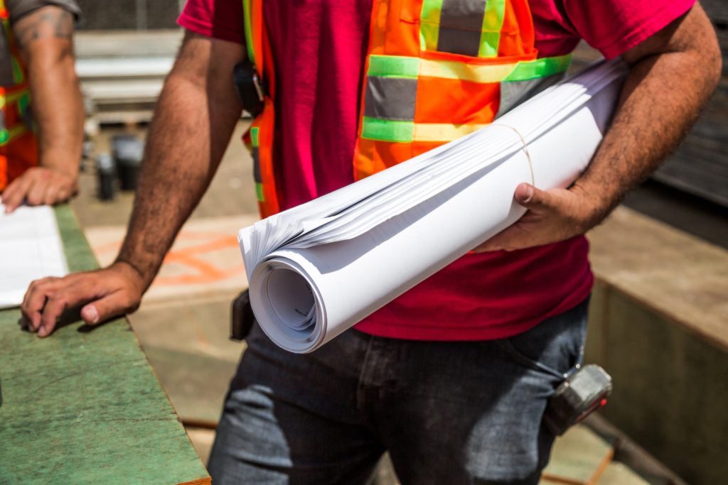 construction worker holding rolled papers